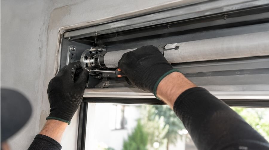 Técnico ajustando el motor tubular de una persiana desde el interior de una vivienda en Tarragona